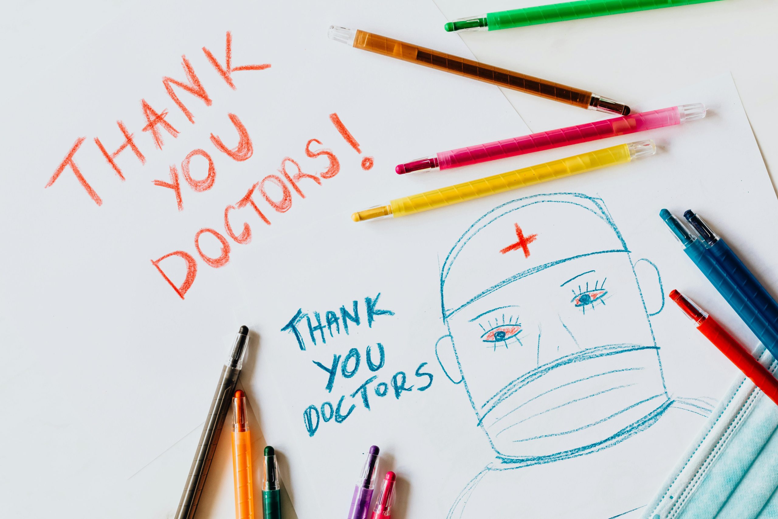 Handwritten thank you notes and drawing of a doctor with color pencils.